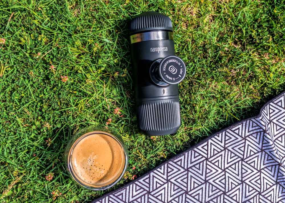 Nanopresso coffee press on grass with cup of coffee and picnic blanket